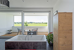 Das Badezimmer mit Sauna und einem Balkon als Frischluftbereich für besondere Wellnessqualitäten.