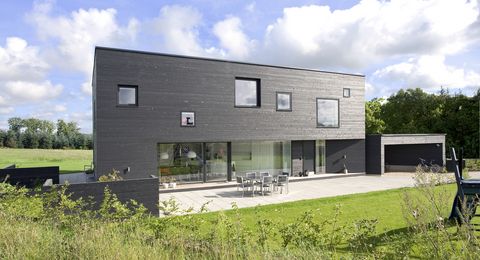 Das skandinavische Funkis 2 Holzhaus in der großen Außenansicht vom Garten aus